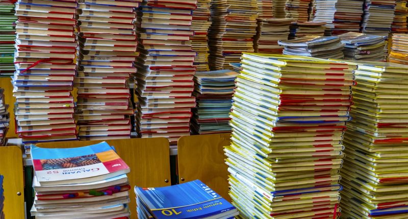 Gymnasieelever med böcker i klassrum