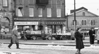 Gatuscen från Göteborg under 1900-talet med människor på snöig väg, butiker med skyltar för Svanströms och Järnaffär, klassicistisk byggnad i bakgrunden.